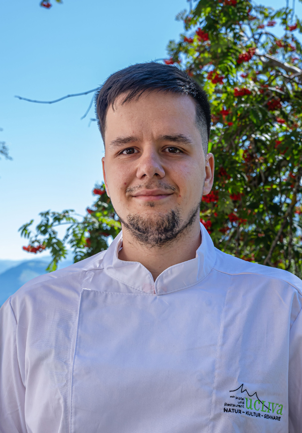 Porträt eines lächelnden Koches in weißer Jacke im Freien